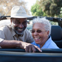 Portrait of senior couple at the back seat of car, smiling
